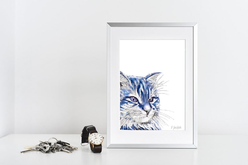 Puede incluir: Una pintura de acuarela enmarcada de un gato azul con pelaje blanco. El gato tiene ojos azules y mira hacia la derecha. La pintura est&aacute; firmada "J Jackson" en la esquina inferior derecha.