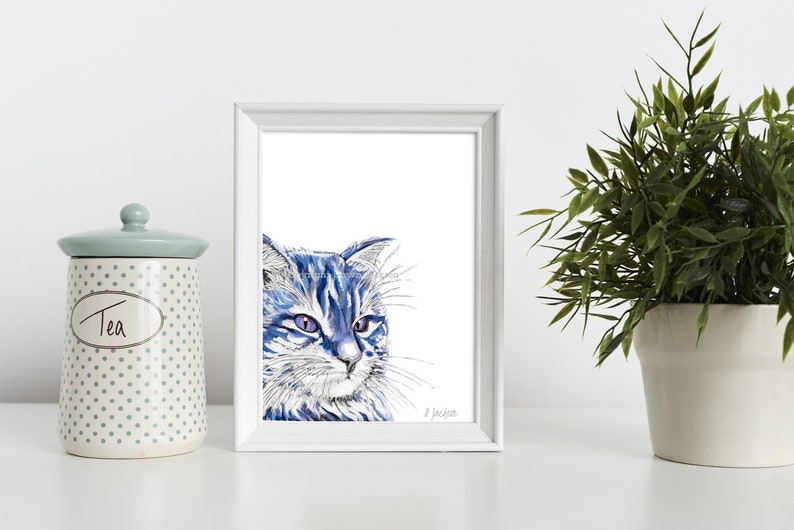 Puede incluir: Una pintura de acuarela enmarcada de un gato azul con pelaje blanco. El gato est&aacute; mirando hacia la derecha y tiene una expresi&oacute;n seria. La pintura est&aacute; sobre un fondo blanco y est&aacute; enmarcada en un marco blanco.