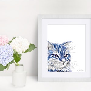 Puede incluir: Una pintura de acuarela enmarcada de un gato azul con ojos morados. El gato est&aacute; mirando hacia la derecha de la imagen. La pintura est&aacute; firmada "D. Jackson".