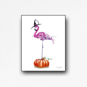 May include: A pink flamingo wearing a black witch hat stands on a small orange pumpkin. The image is a watercolor painting with the artist's signature in the bottom right corner.
