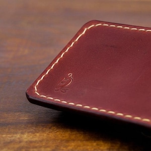 Leather pencil case with compartment in mahogany color lying on a wooden board