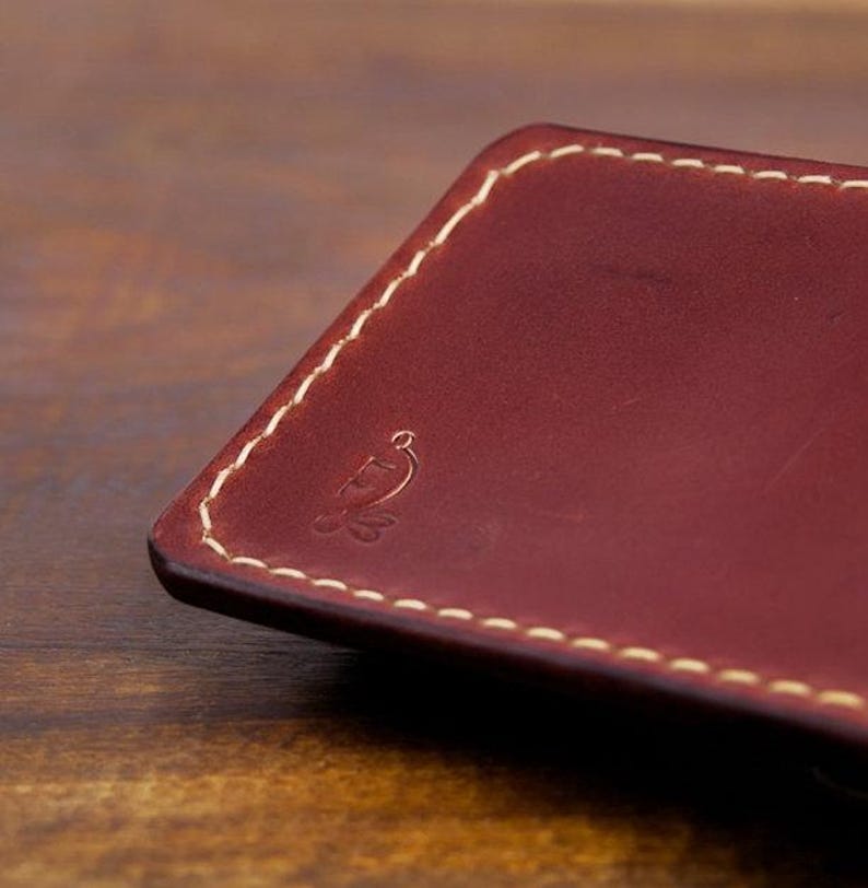 Leather pencil case with compartment in mahogany color lying on a wooden board