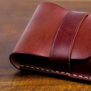 Leather pencil case with compartment in mahogany color lying on a wooden board