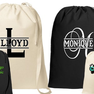 May include: Two personalized laundry bags, one beige with the name "LLOYD" and the other black with the name "MONIQUE". Both bags have a drawstring closure and are made of canvas.