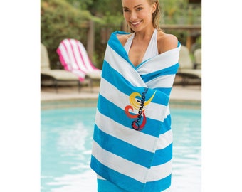 May include: A blue and white striped beach towel with the text "Oceanshores" embroidered in colorful lettering.