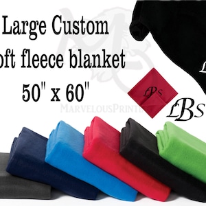 May include: A selection of soft fleece blankets in various colours, including grey, navy blue, royal blue, red, and green. The blankets are arranged in a stack, with the largest blanket at the bottom and the smallest blanket at the top. The blankets are all 50 inches by 60 inches. The text "Large Custom Soft Fleece Blanket 50" x 60" is printed on the image.