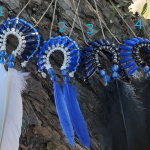May include: Four dreamcatchers with blue and silver beads, each with a different color feather: white, blue, black, and black.