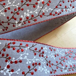 以下が含まれることがあります： 白と茶色の花柄と赤いグリッターベリーが付いたグレーのリボン