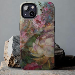 May include: A phone case with a floral design featuring a hummingbird in flight. The case has a textured, painted look with shades of pink, green, and yellow.