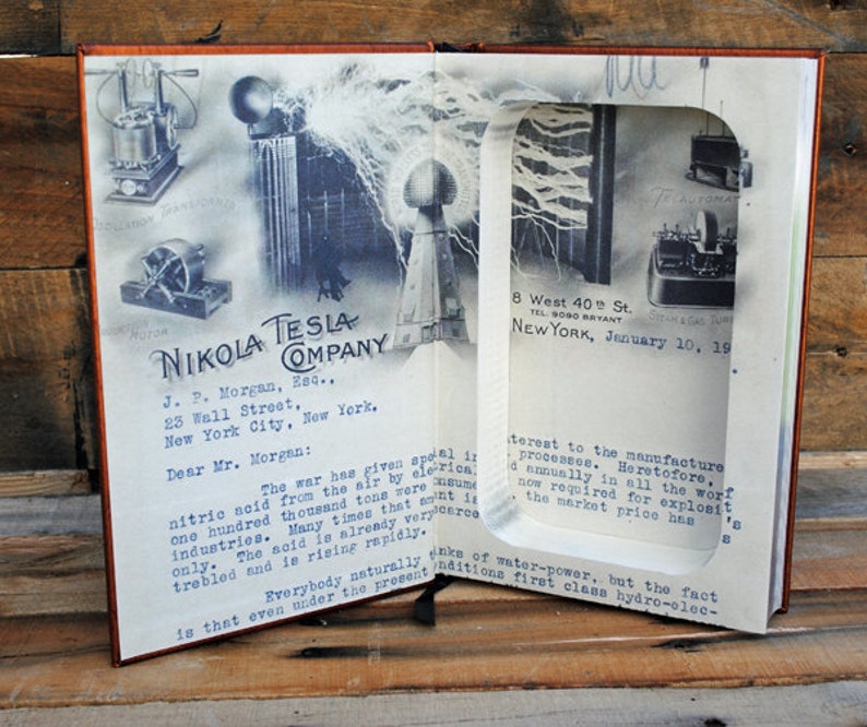 May include: A vintage letter from Nikola Tesla Company to J.P. Morgan, dated January 10, 1919, discussing the importance of nitric acid production during wartime. The letter is displayed in a book with a cut-out window revealing a vintage photograph of Tesla's inventions.