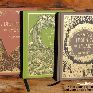 May include: Three hardcover books with gold foil lettering and illustrations. The books are titled "A Dictionary of Tolkien", "An Atlas of Tolkien", and "The Ring Legends of Tolkien" by David Day. Each book has a different color spine.