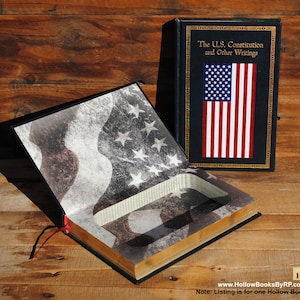 Può includere: Un caveau di libro vuoto travestito da un libro intitolato "The U.S. Constitution and Other Writings". Il libro è aperto per rivelare un vano nascosto all'interno. La copertina del libro presenta un design di bandiera americana sbiadito con stelle e strisce.