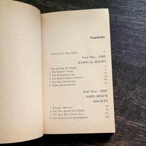 K&ouml;nnte beinhalten: Aufgeschlagenes Buch mit Inhaltsverzeichnis. Der Titel lautet "Contents" mit den Abschnitten "Part One - The Radical Right" und "Part Two - The John Birch Society". Die Seiten sind cremefarben mit schwarzem Text.