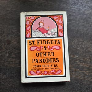 May include: A vintage paperback book titled "ST. FIDGETA & OTHER PARODIES" by John Bellairs, illustrated by Marilyn Fitshen. The cover features an illustration of a cartoon angel and a pink and orange design.