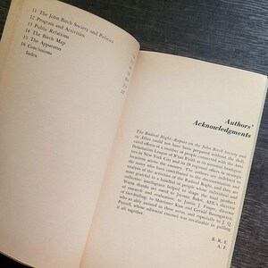 K&ouml;nnte beinhalten: Offenes Buch mit Text auf gealtertem Papier. Die linke Seite listet Kapitel&uuml;berschriften auf: The John Birch Society and Politics, Program and Activities, Public Relations, The Birch Map, The Apparatus, Conclusions und Index.