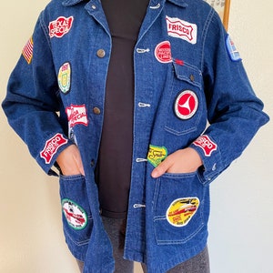 Könnte beinhalten: Eine blaue Jeansjacke mit verschiedenen Patches, darunter "Frisco Lines", "Texas Special" und "Missouri Pacific Lines".