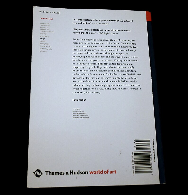 以下が含まれることがあります： Thames & Hudsonの「World of Art」というタイトルの本。表紙にはファッションの歴史に関するテキストと引用があり、背表紙は赤と白です。この本の第5版は、古代から現代のトレンドまでのファッションをカバーしています。