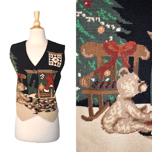 May include: Black Christmas-themed vest with a V-neck and button closure. The vest features a tapestry design with a Christmas tree, teddy bears, a fireplace, and a rocking chair. The bottom hem is a light tan color.