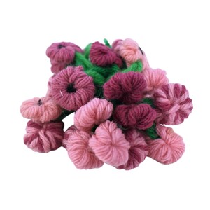 Peut inclure: Un bouquet fait à la main de fleurs en fil de couleur rose et bordeaux, avec des feuilles en fil vert. Les fleurs ont un aspect texturé et tridimensionnel, sur fond blanc.