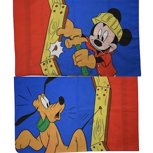 Könnte beinhalten: Zwei Kissenbezüge mit Mickey Mouse und Pluto. Mickey, mit gelbem Helm und rotem Hemd, hämmert auf ein Holzbrett. Pluto, mit grünem Halsband, schaut überrascht. Der Hintergrund ist blau und rot, im Cartoon-Stil.