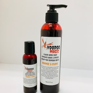 May include: Two bottles of Voodoo Magic liquid hand soap. The larger bottle has a pump dispenser and the smaller bottle has a black cap. The labels read "Orange & Clove" and "Removes Odor & Spices Great for Seafood Boils."