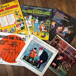 May include: A collection of vintage vinyl records featuring children's music and classic stories. The records include titles like "Disney's Children's Favorites", "The Wizard of Oz", "Music for 1's & 2's", "The Sorcerer's Apprentice", and "Peter and the Wolf".