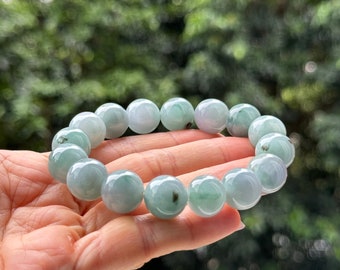 May include: A jadeite bracelet with light green beads. The bracelet is made of natural jade and has a polished finish.