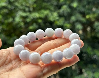 May include: A lavender jade bracelet with round beads. The bracelet is made of natural jade and has a smooth, polished finish.