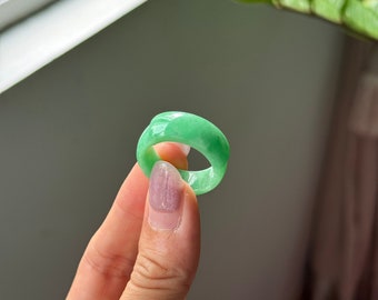 May include: A light green jade ring with a smooth, polished finish.