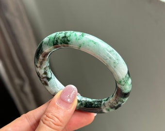 Op de afbeelding: Een groene jade armband met een wit en zwart marmerpatroon.