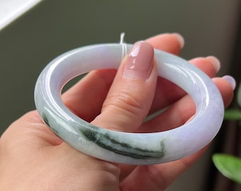 May include: A light lavender jade bangle with a green and white swirl pattern.
