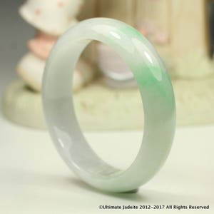 Può includere: Un braccialetto di giada di colore verde chiaro, con una finitura liscia e lucida.