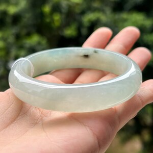 Può includere: Un braccialetto di giada di colore verde chiaro con una finitura lucida.