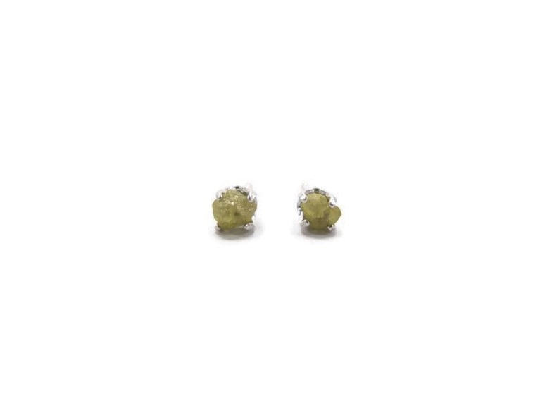 May include: A pair of silver stud earrings with small, rough, green gemstones.