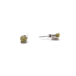 May include: A pair of silver stud earrings with small, rough, green gemstones.