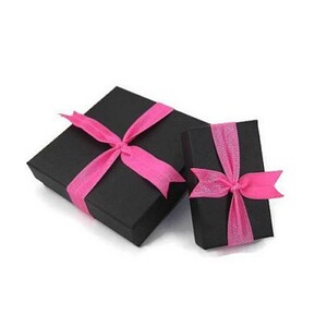 May include: Two black gift boxes with pink ribbon bows. The larger box is slightly larger than the smaller box.