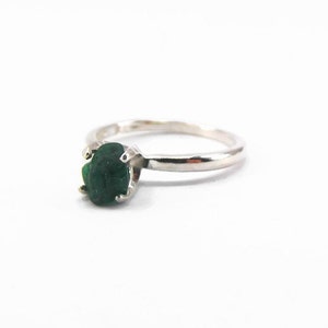 Puede incluir: Un anillo de plata con una piedra ovalada verde oscura.