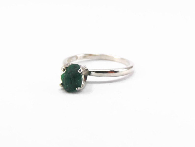Puede incluir: Un anillo de plata con una piedra ovalada verde oscura.