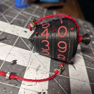 Chromatic collection. 
Dials - Black
Numbers - Red
Top/Bottom/Core - Black
Gem/Cord - Red