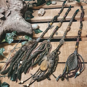 May include: Four green, brown, and burgundy braided hair extensions with feathers, beads, and charms. The extensions have a bohemian style.