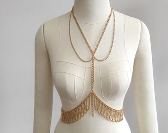 May include: Gold chain body jewelry with a layered design and a fringe detail.