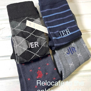 May include: Three pairs of men's socks with different patterns and colors. The socks are monogrammed with the initials "JER".