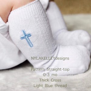 May include: White baby socks with a light blue embroidered cross. The socks are labeled "Pattern Straight-top", sized for 0-3 months, with a "Thick Cross" design, and made with "Light Blue thread". The brand name "NYLAKELLEYdesigns" is also visible.