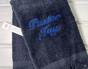 以下が含まれることがあります： フリンジの縁取りと青い刺繍で「Pastor Jay」と書かれた黒いタオル