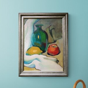 Discover the beauty of our vibrant still life original oil painting, a stunning piece of framed artwork that brings a touch of vintage charm to any space. This one of a kind hand-painted canvas features an exquisite arrangement of fruits and a bottle, captured in an impressionist style that radiates color and warmth. Whether you're looking to enhance your kitchen decor or add a focal point to your dining area, this unique art piece serves as a delightful addition to your home.