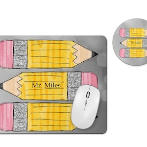May include: A gray mousepad and coaster set featuring a pencil design. The mousepad has three yellow pencils with pink erasers and the text "Mr. Miles." The coaster has three smaller pencils. A white computer mouse is also present.