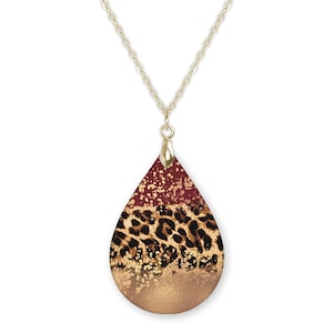 May include: Gold chain necklace with a teardrop-shaped pendant featuring a layered design of burgundy, leopard print, and gold glitter.