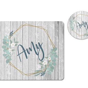 May include: A white woodgrain background with a gold geometric frame and a leafy floral design. The name "Amy" is written in blue inside the frame.