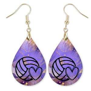 May include: Purple and gold watercolor-style teardrop earrings with a black volleyball and heart design.