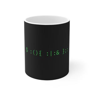 May include: A black ceramic mug with a white interior featuring the green text $:(){ :|:& };: printed on the front. The mug has a cylindrical shape with a smooth matte finish and a standard handle, displaying a computer code fork bomb command.